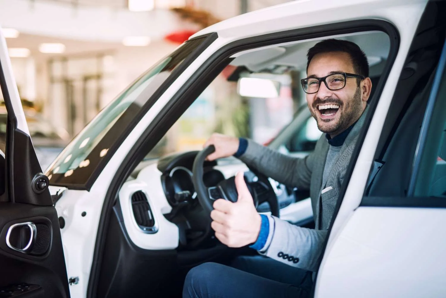 A driver sitting behind the wheel of a newly covered car